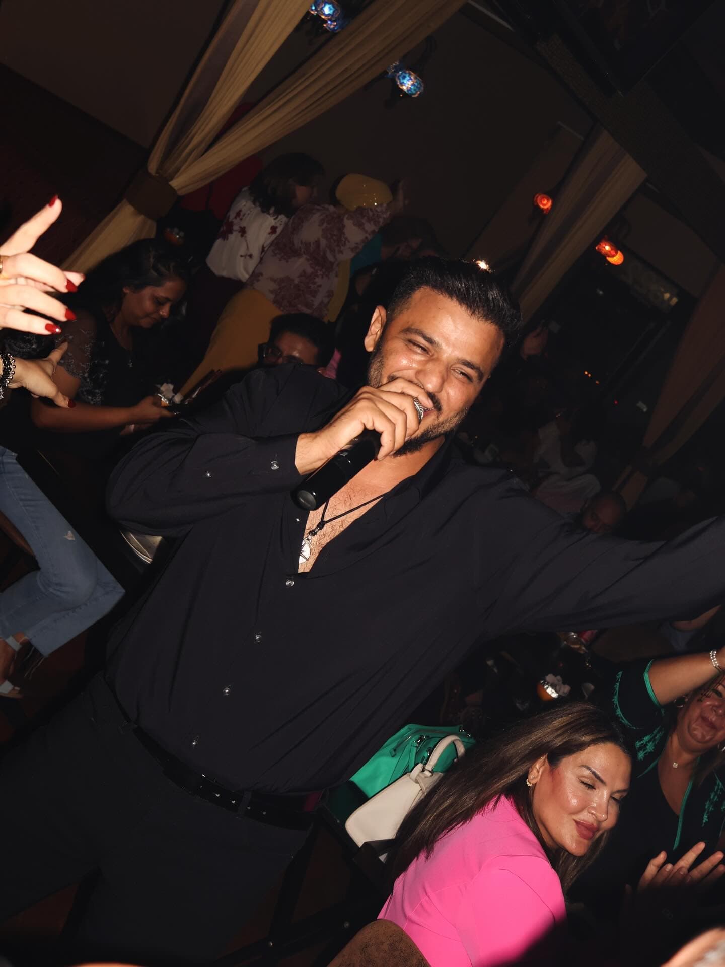 The singer mid-song in the middle of a packed room at KZ